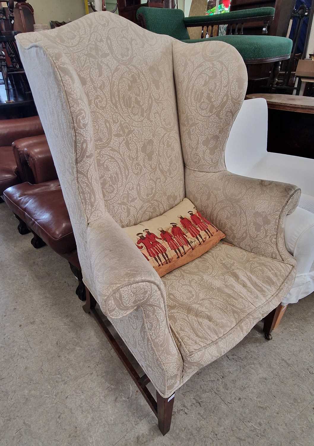 A George III mahogany wing armchair with floral upholstered back, arms and loose cushion seat,