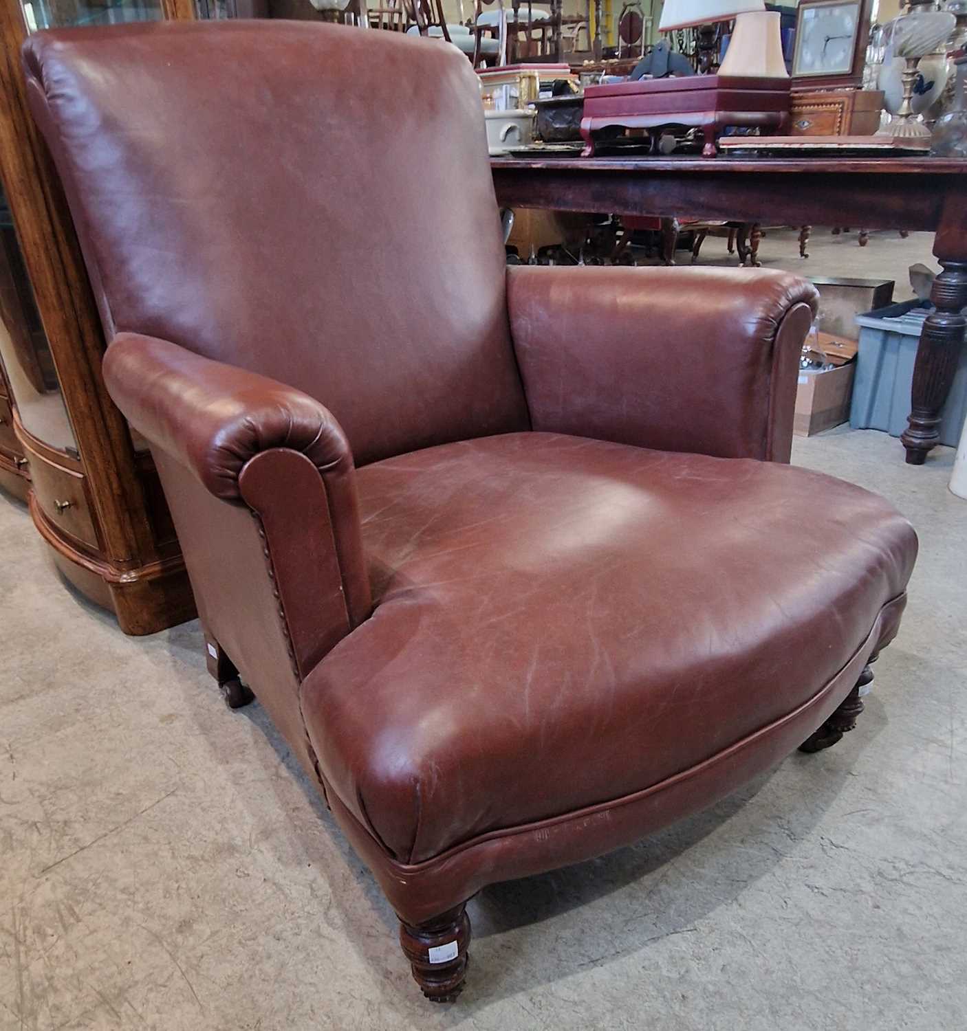 A Victorian oak brown leather upholstered club arm chair with studded detail.
