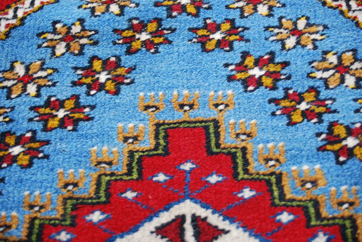 A Turkish rug, 20th century, the rectangular madder ground centred with a blue ground lozenge - Image 4 of 4
