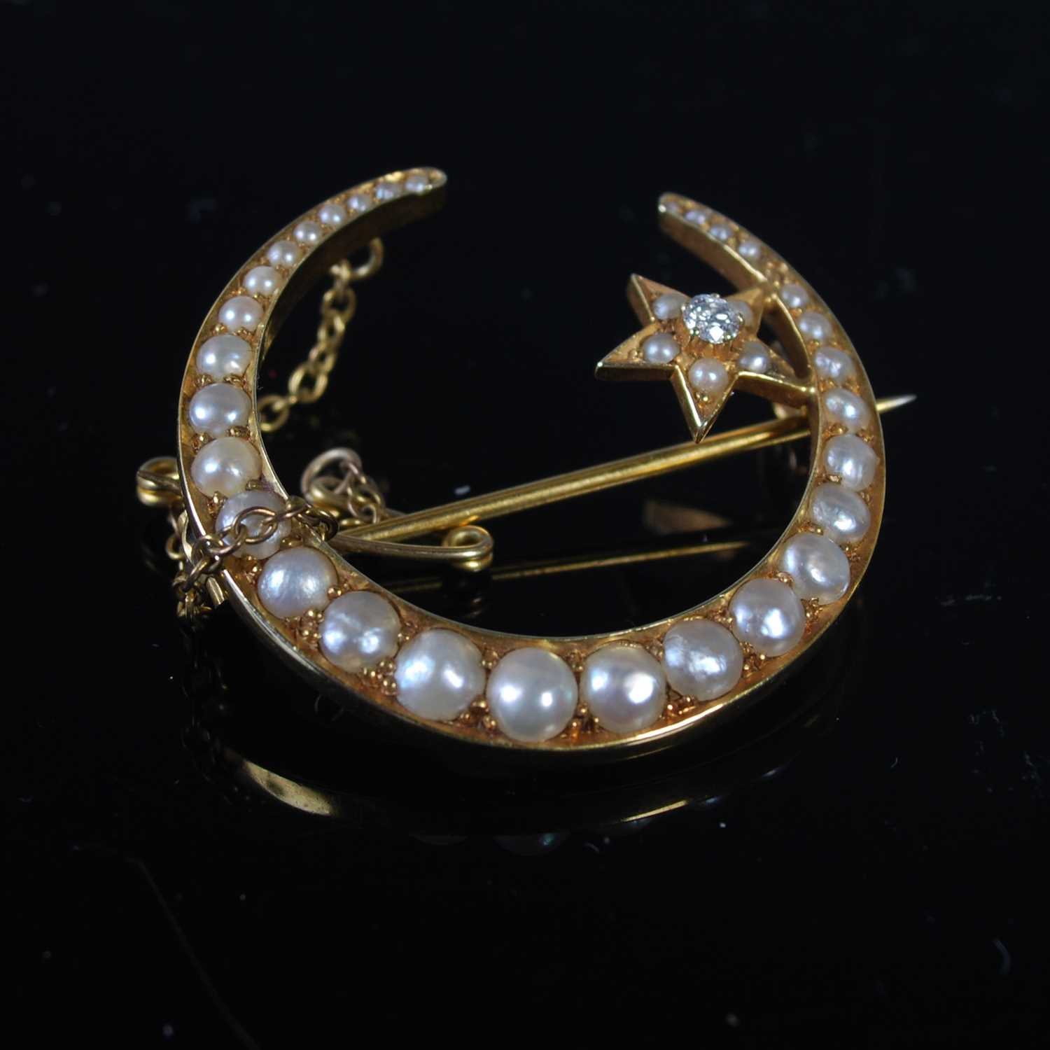Late 19th century yellow metal diamond and split pearl crescent shaped brooch set with a star,
