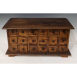 A stained wood table top chest of eighteen small drawers, raised on four bracket feet, 32.5cm