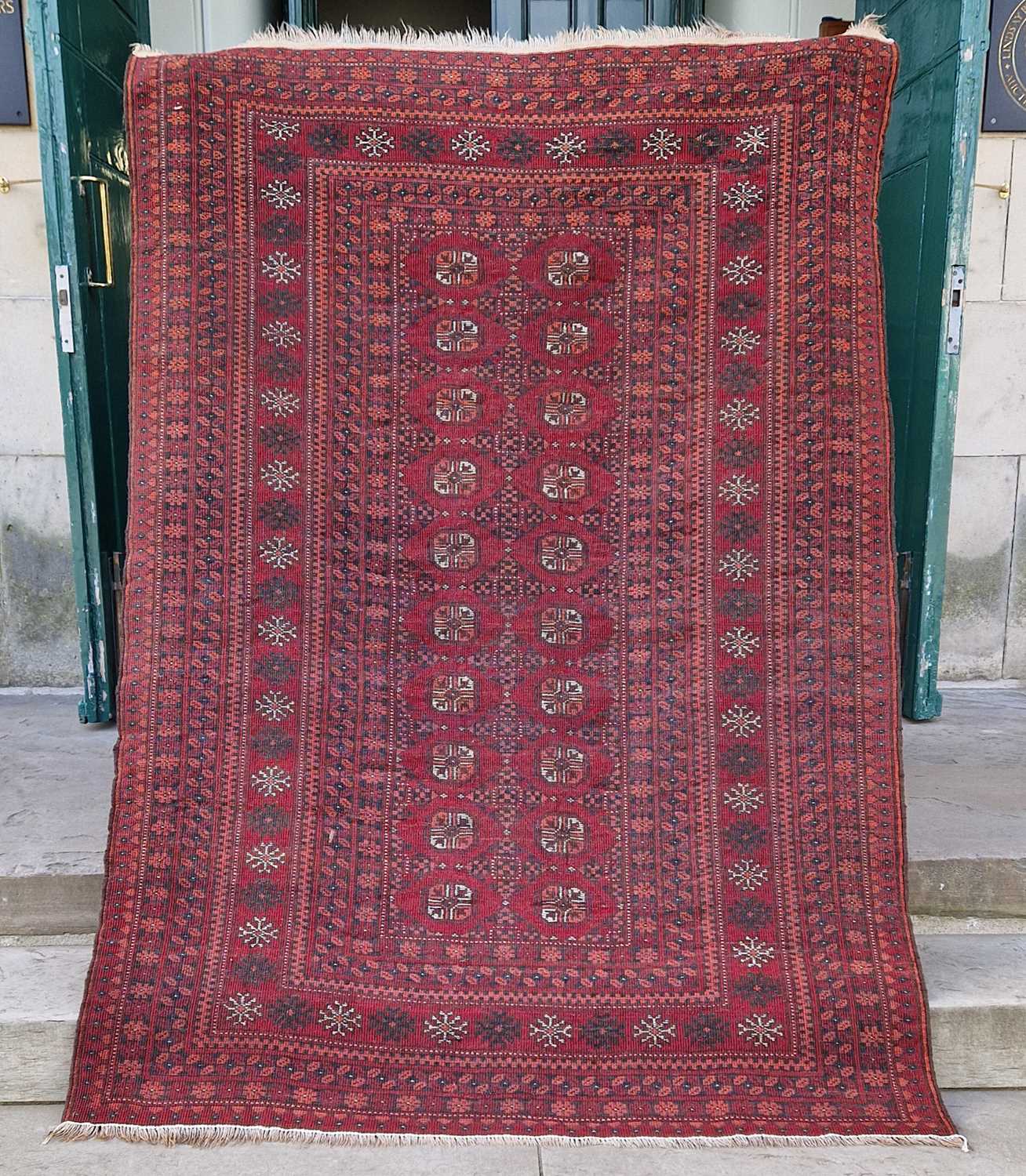 A Persian Tekke rug, the rectangular madder ground centred with two rows of twenty octagonal - Image 2 of 4