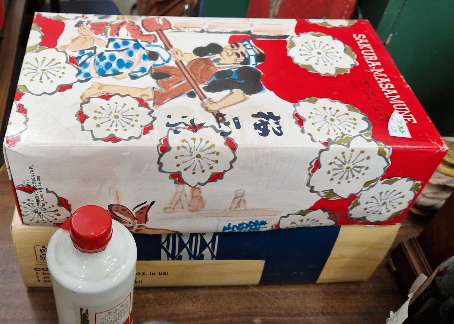 Three bottles, a Sakura-Masamune Japanese sake with sake server and four cups in original box, a