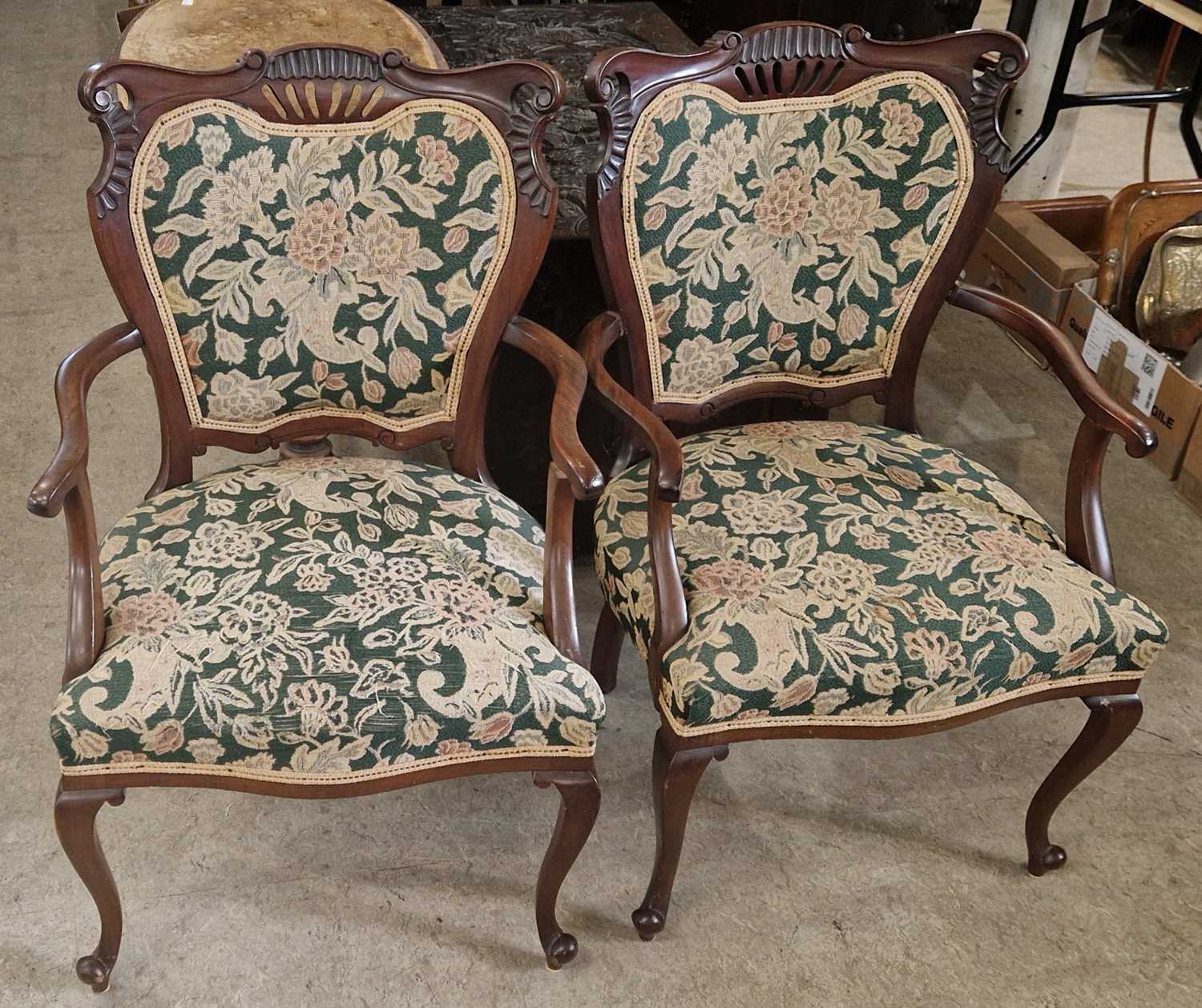 A pair of Edwardian mahogany upholstered armchairs.