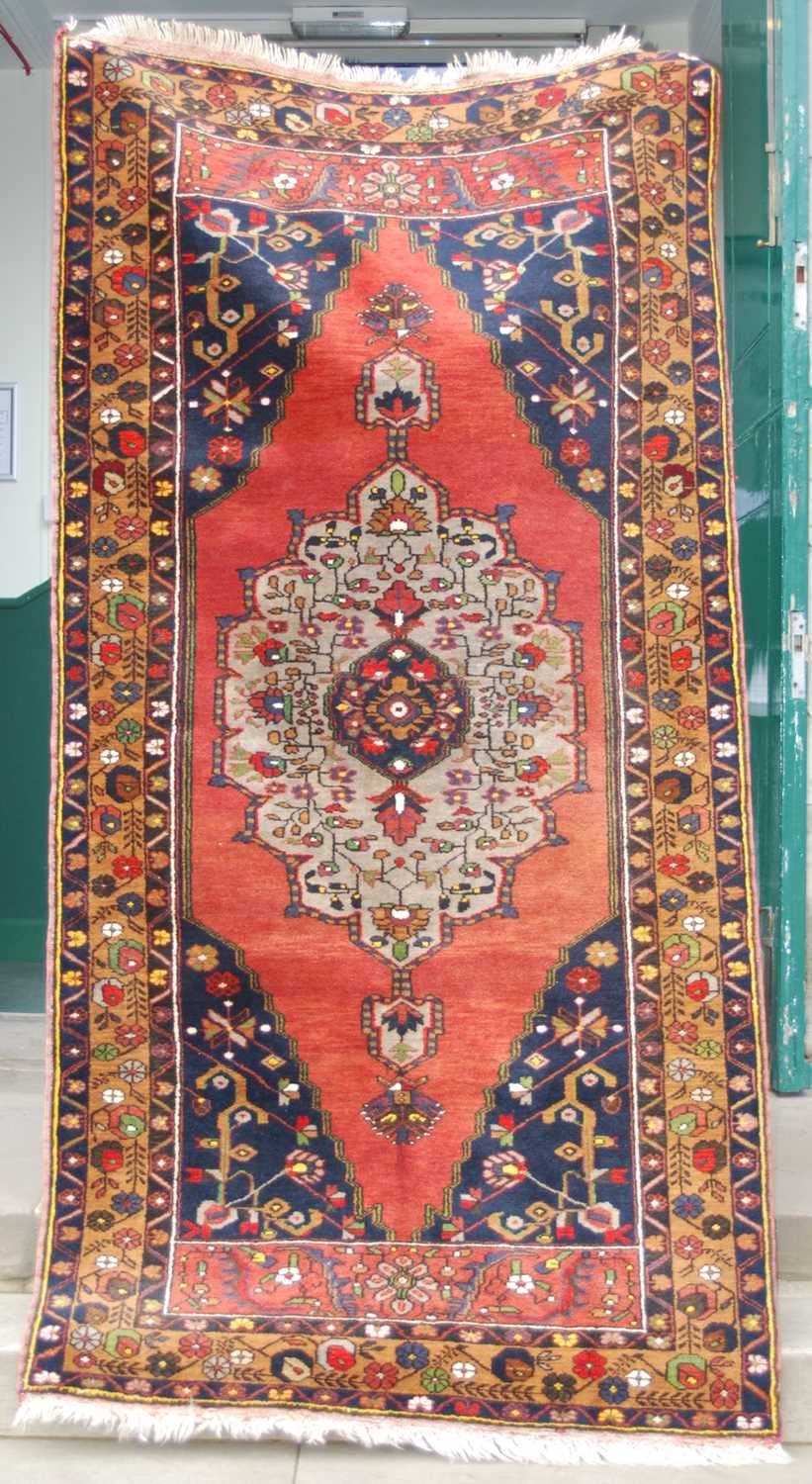 A Turkish long rug, 20th century, the rectangular abrashed madder ground centred with a large oval - Image 2 of 6