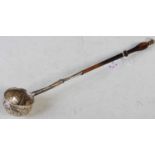 A late 18th/ early 19th century white metal toddy ladle with embossed flower and foliate decorated