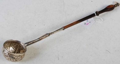 A late 18th/ early 19th century white metal toddy ladle with embossed flower and foliate decorated