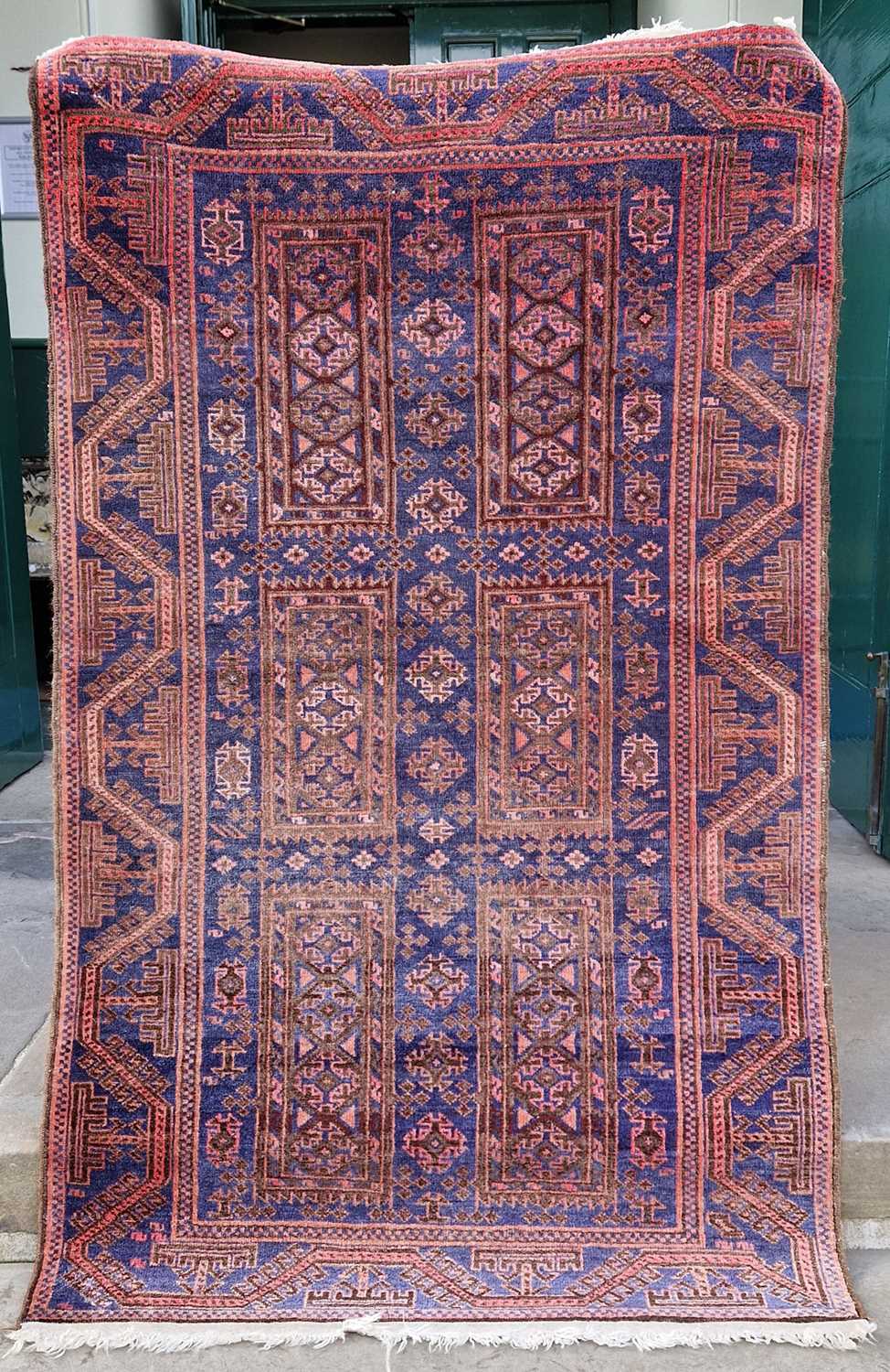 A Persian rug, mid 20th century, the rectangular blue ground decorated with six rectangular shaped