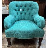 An Edwardian mahogany armchair with blue/green brocade upholstery, raised on tapered square supports