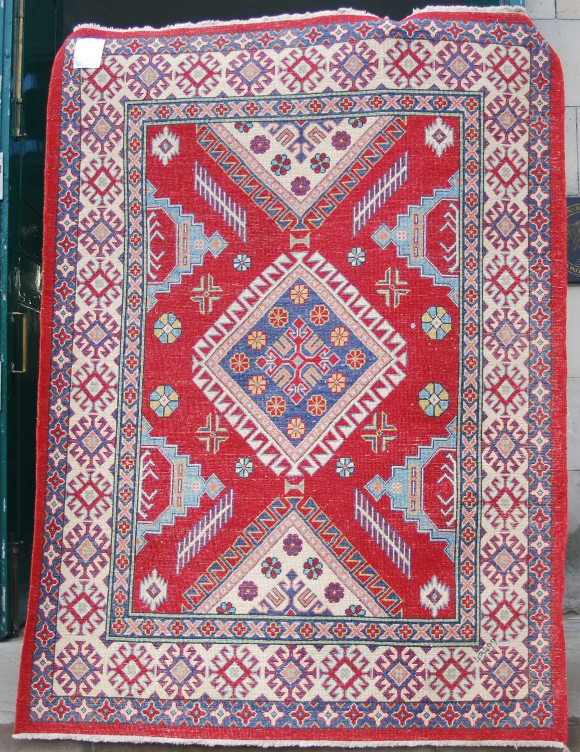 An Afghan Kazak rug, 20th century, the rectangular madder ground centred with a large blue ground - Image 2 of 5