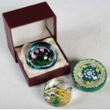 Three assorted millefiori glass paperweights to include a green ground weight by Jack Allen,