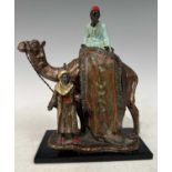 A cold painted spelter figure group of two Arabs and a camel, the mounted figure holding a rug, 18cm