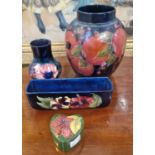 A group of four pieces of Moorcroft pottery to include a blue ground jar decorated with