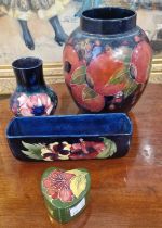 A group of four pieces of Moorcroft pottery to include a blue ground jar decorated with