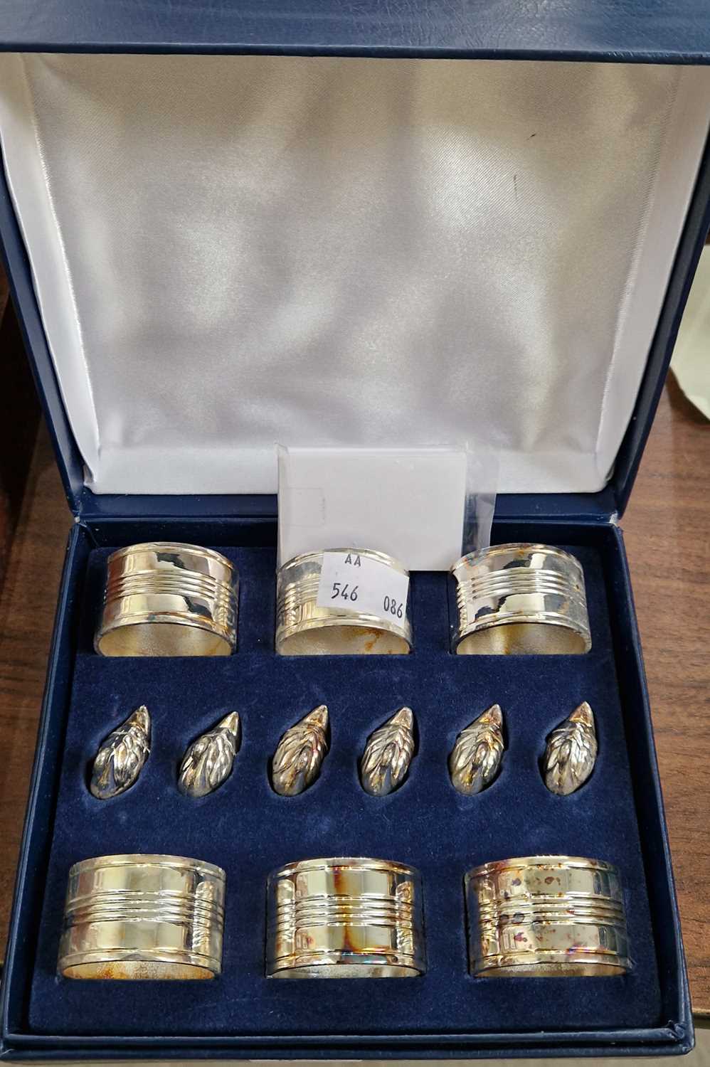 A cased set of six napkin rings and six duck form menu card holders.
