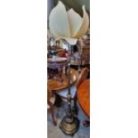 An early 20th century brass rise and fall standard lamp with lotus shaped shade, extended height