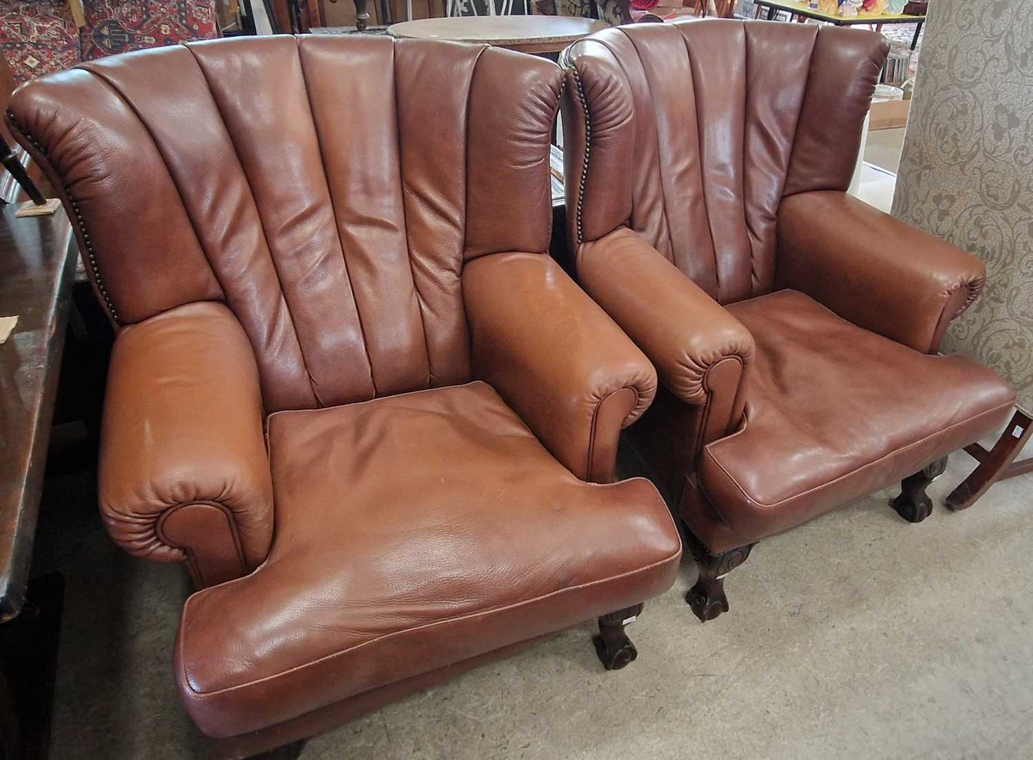 A pair of 20th century brown leather upholstered armchairs, the curved backs with pleated brown