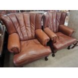 A pair of 20th century brown leather upholstered armchairs, the curved backs with pleated brown