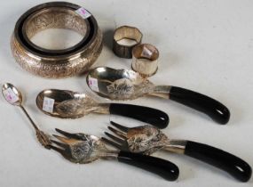 A collection of Eastern white metal wares to include a circular dish, two napkin rings, teaspoon and