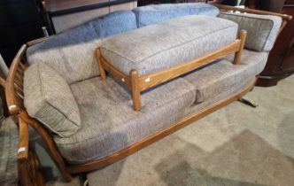A modern wood framed sofa, arm chair and matching rectangular footstool.