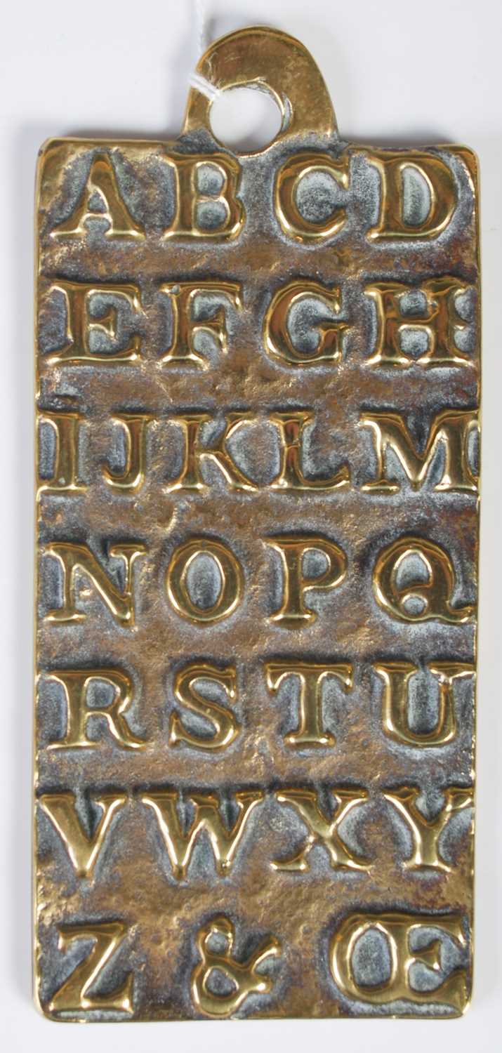 An antique brass alphabet plaque teaching aid, the reverse inscribed 'St. Pauls AD1729', cast in