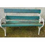 A cast iron and wood garden bench, the ends cast with fruit and foliage, with white and green