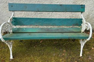 A cast iron and wood garden bench, the ends cast with fruit and foliage, with white and green