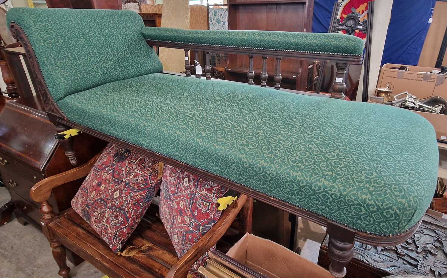 A Victorian oak chaise longue with green upholstered back, arm and seat, with brass studded