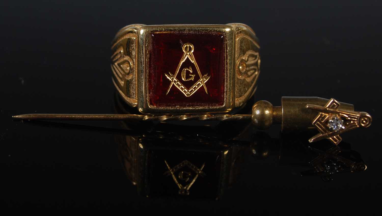 Two pieces of Masonic jewellery to include a yellow metal signet ring with intaglio carved red stone