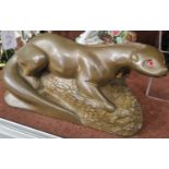 An Art Deco style bronzed composite figure of an otter with red facet cut inlaid glass eyes,