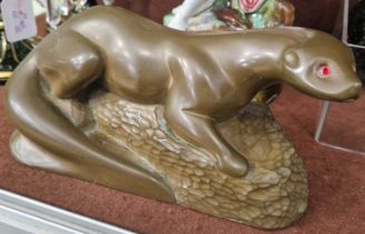 An Art Deco style bronzed composite figure of an otter with red facet cut inlaid glass eyes,