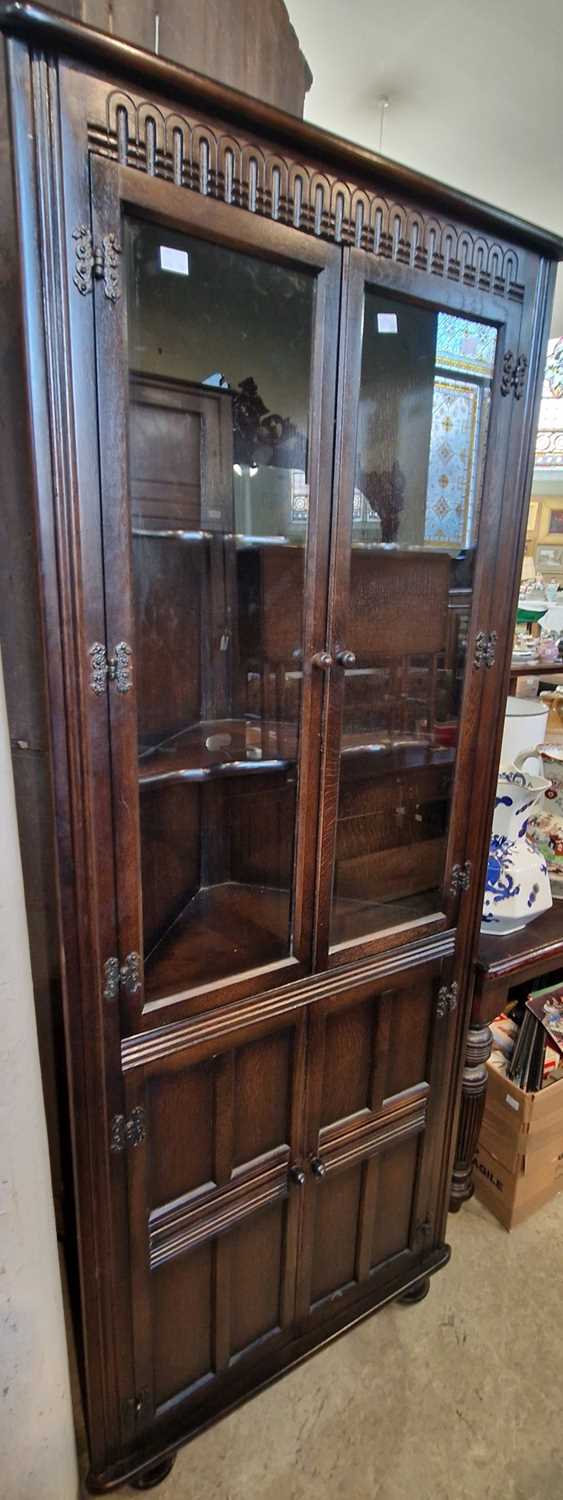 A stained oak corner cupboard.