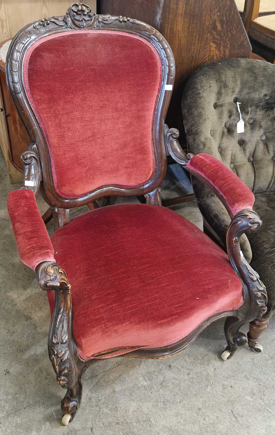 A Victorian walnut armchair with claret coloured velvet upholstered back, arms and seat.