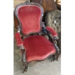 A Victorian walnut armchair with claret coloured velvet upholstered back, arms and seat.