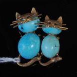 A yellow metal mounted turquoise cabochon stone double cat brooch, stamped '750', 32.1mm long, gross