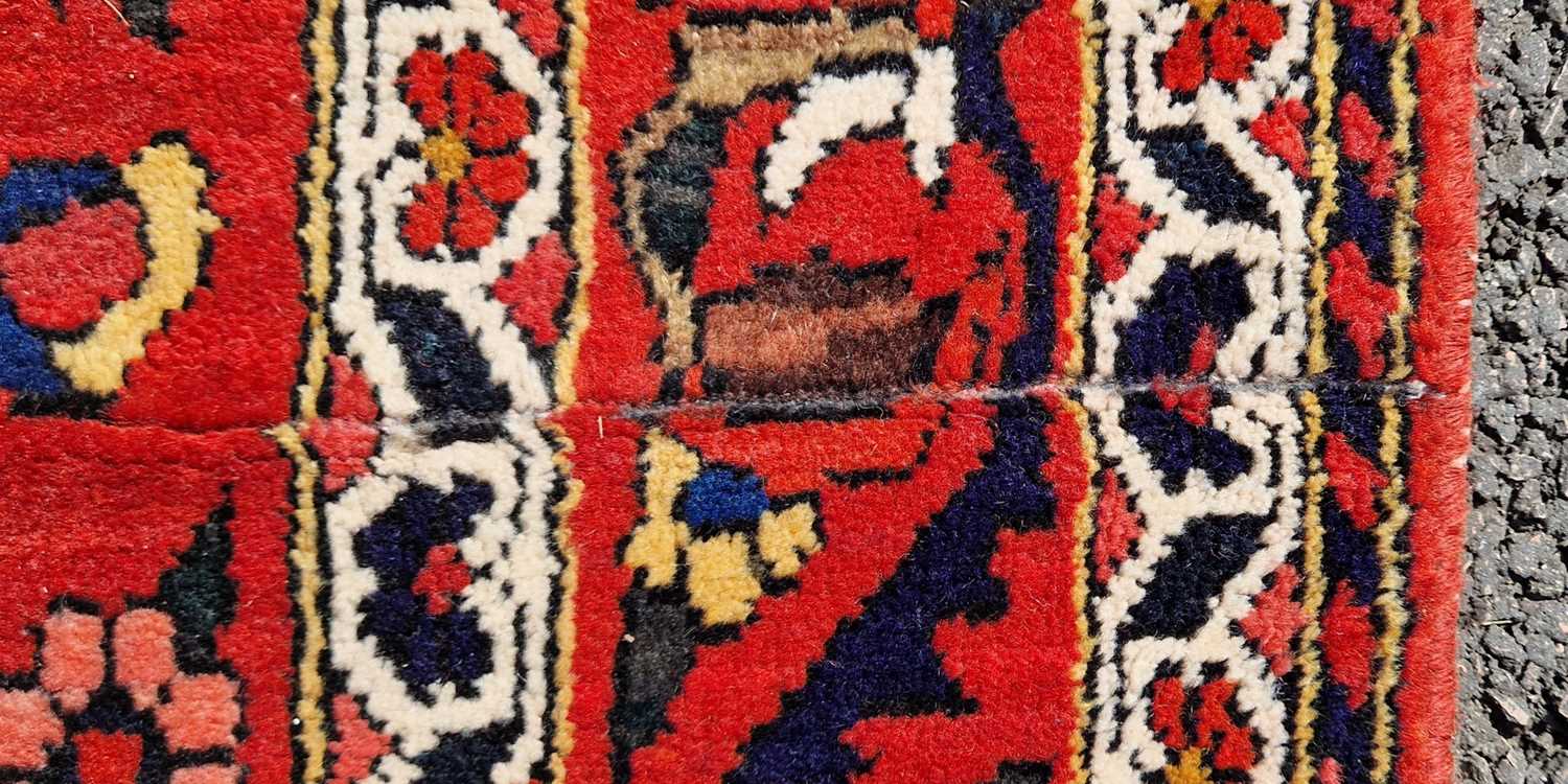 A Persian rug, 20th century, the rectangular madder ground centered with a blue ground oval - Image 4 of 5