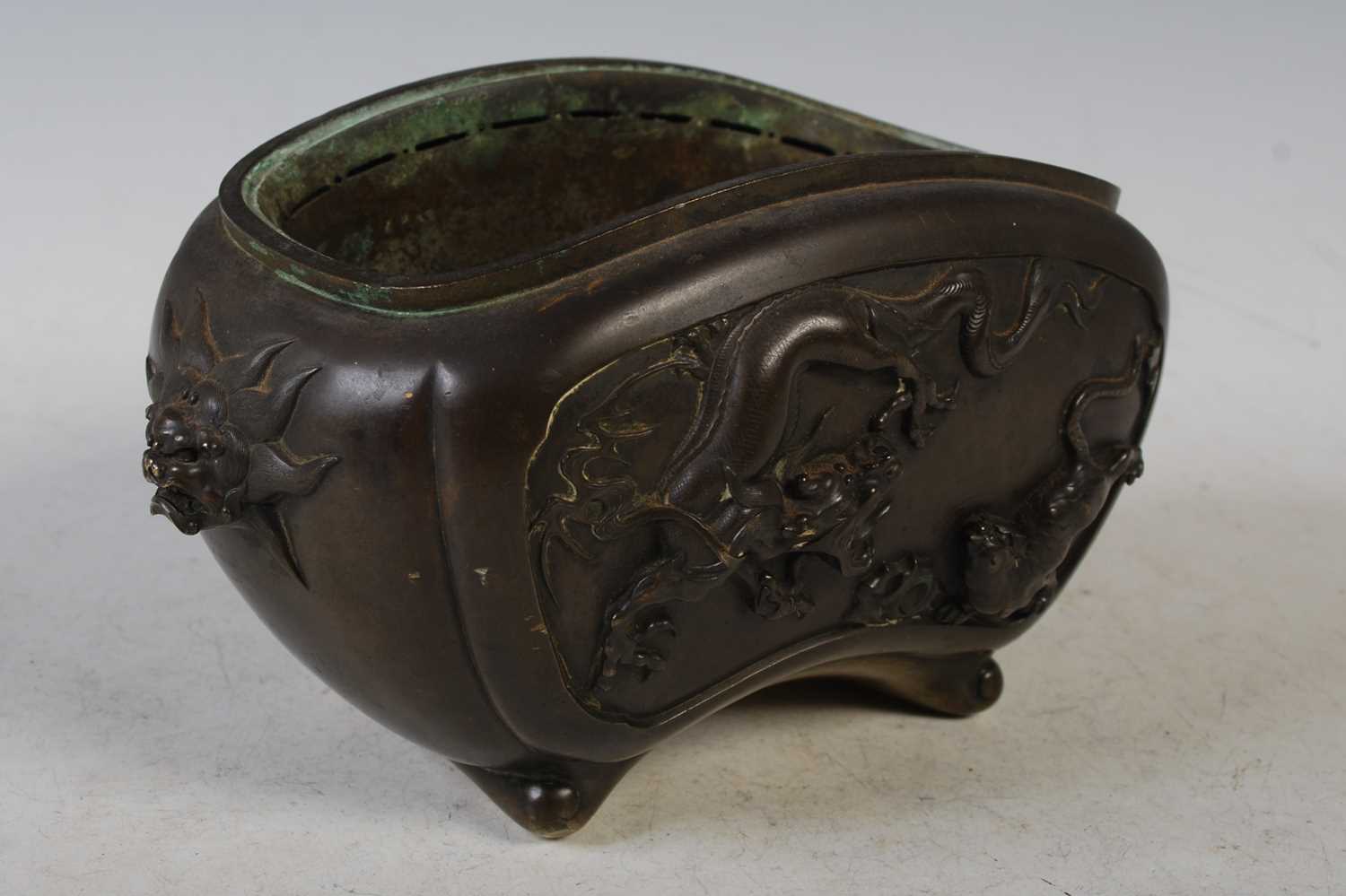 A late 19th century Japanese bronze censor, decorated in relief with Kylin and dragon, the sides