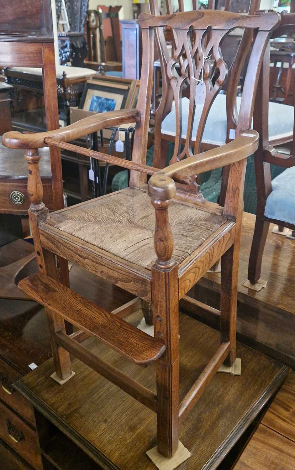 An antique childs highchair in the George III style, with drop in woven string seat, pull out safety