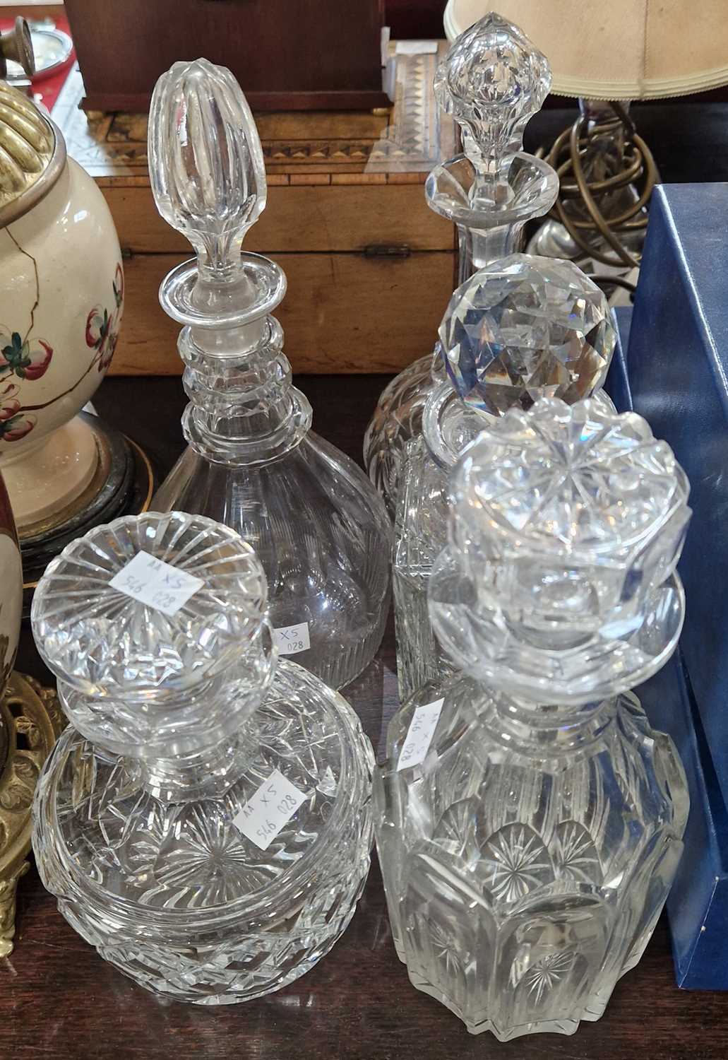 Five assorted glass decanters and stoppers.