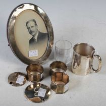 A collection of silver to include oval strut frame, Christening mug, three various napkin rings, two
