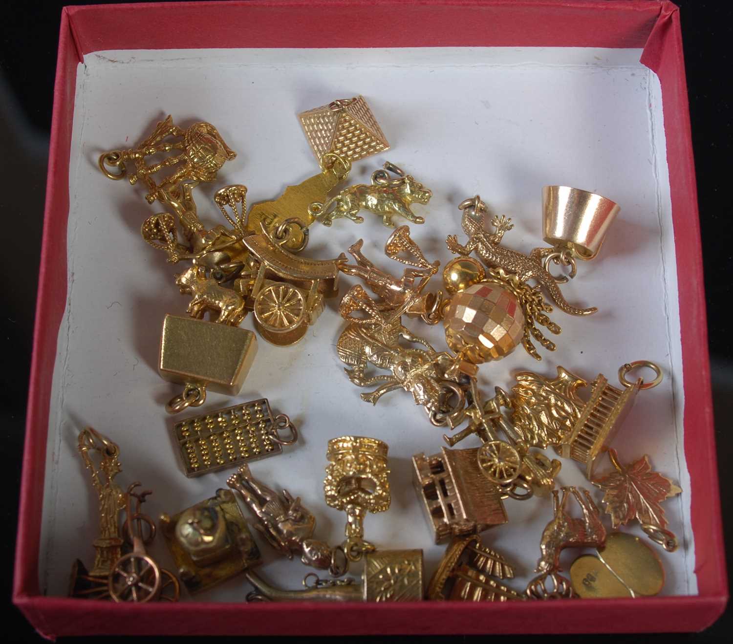A collection of twenty eight assorted gold and yellow metal charms, gross weight 75 grams.