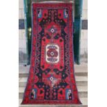 A Persian long rug, 20th century, the charcoal coloured ground centred with an ivory medallion and