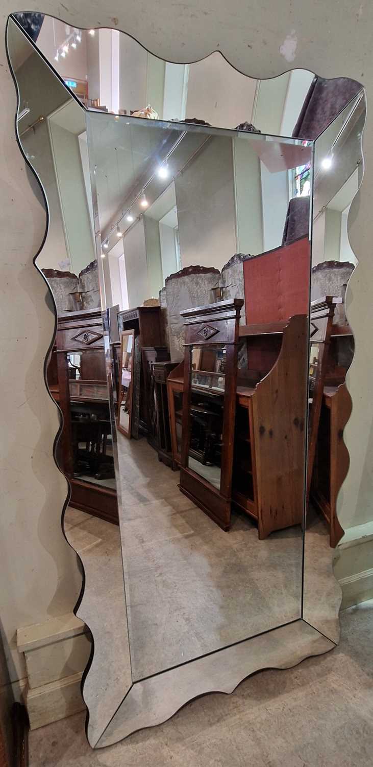 A contemporary rectangular wall mirror, the central bevelled mirror plate surrounded by shaped