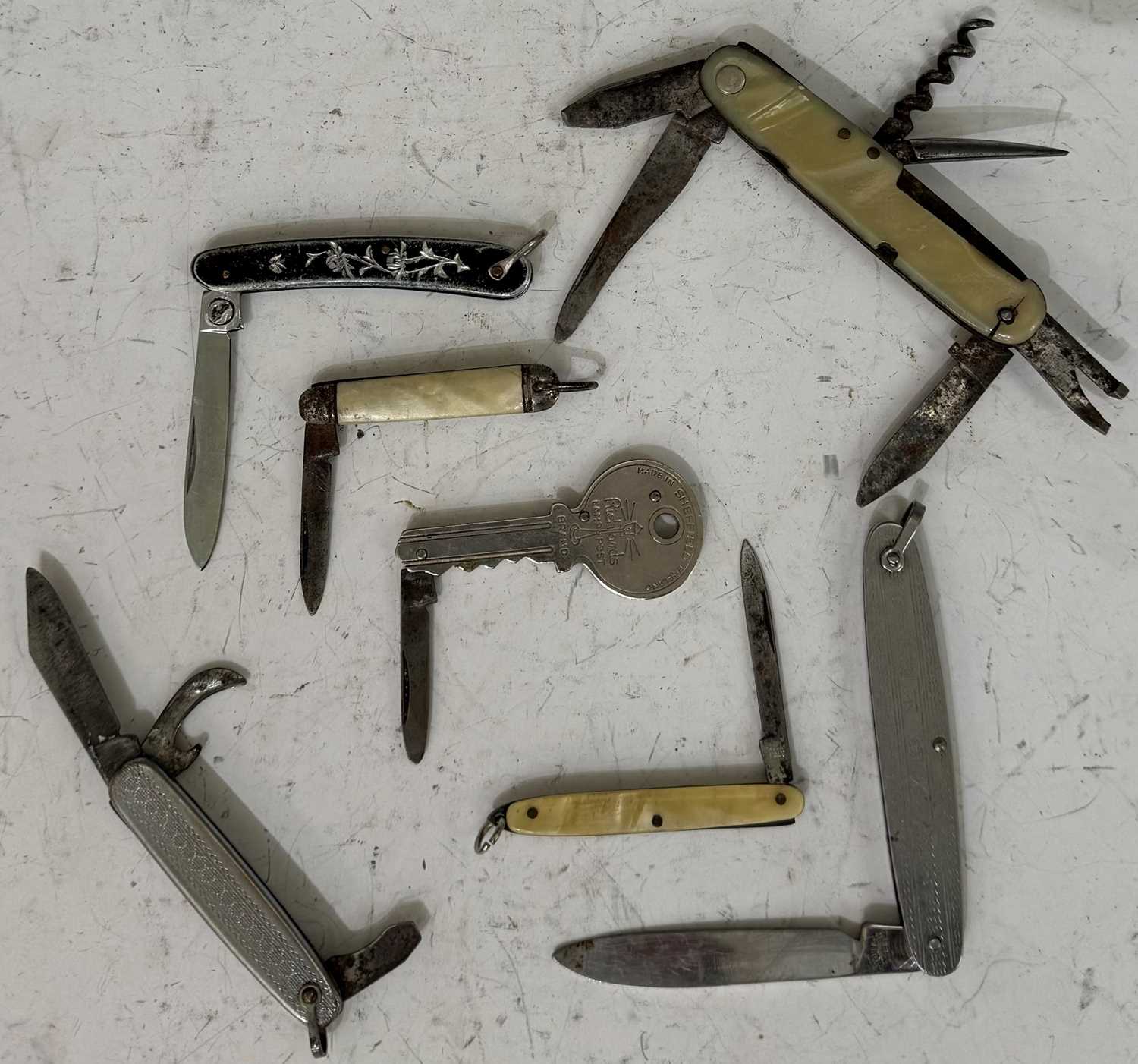 A collection of seven assorted vintage pocketknives to include one in the form of a key.