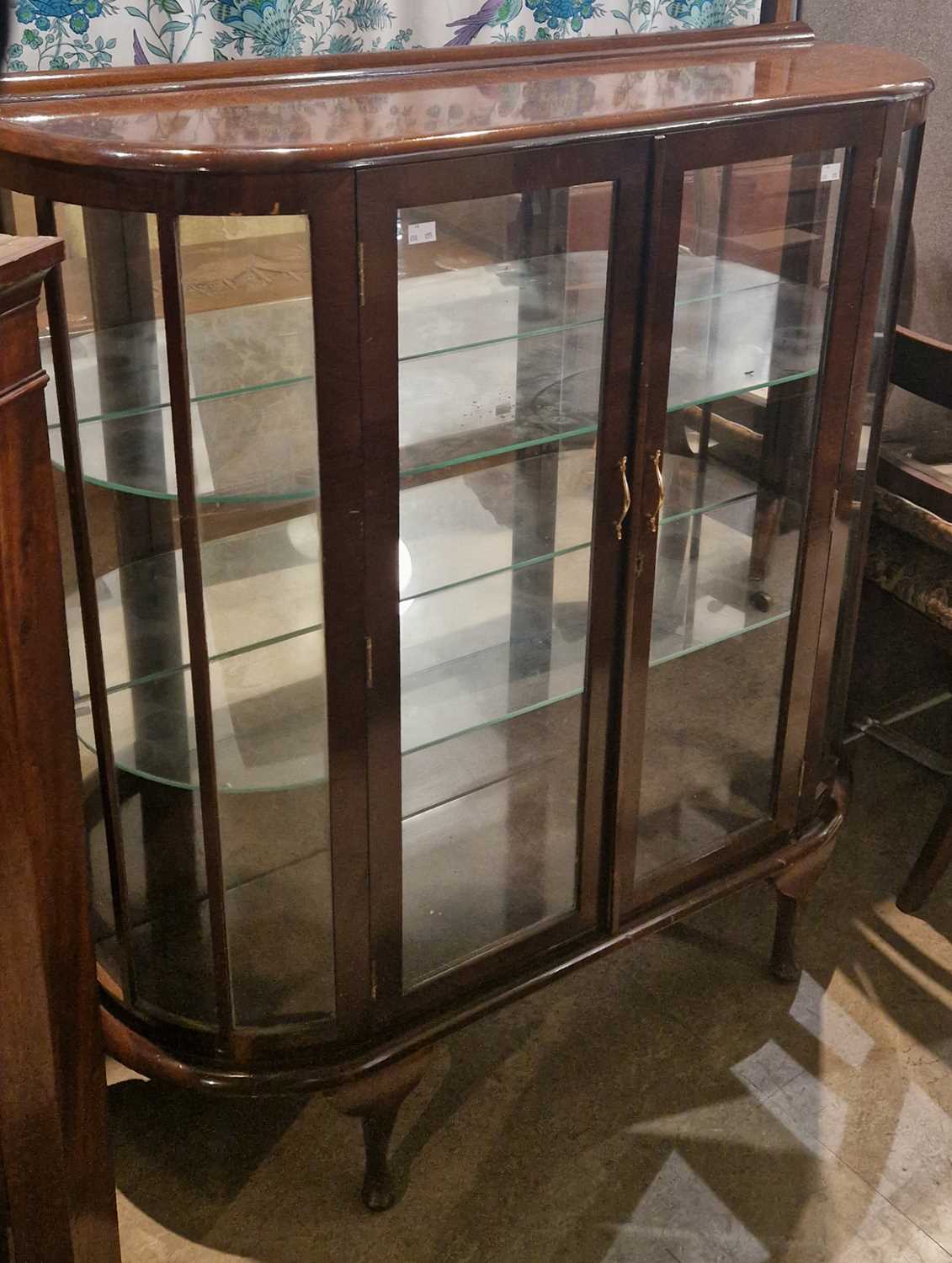 A vintage mahogany glazed display cabinet, the glazed double doors opening to an interior with