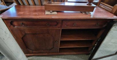 A 20th century stained oak side cabinet fitted with two frieze drawers over a cupboard door and