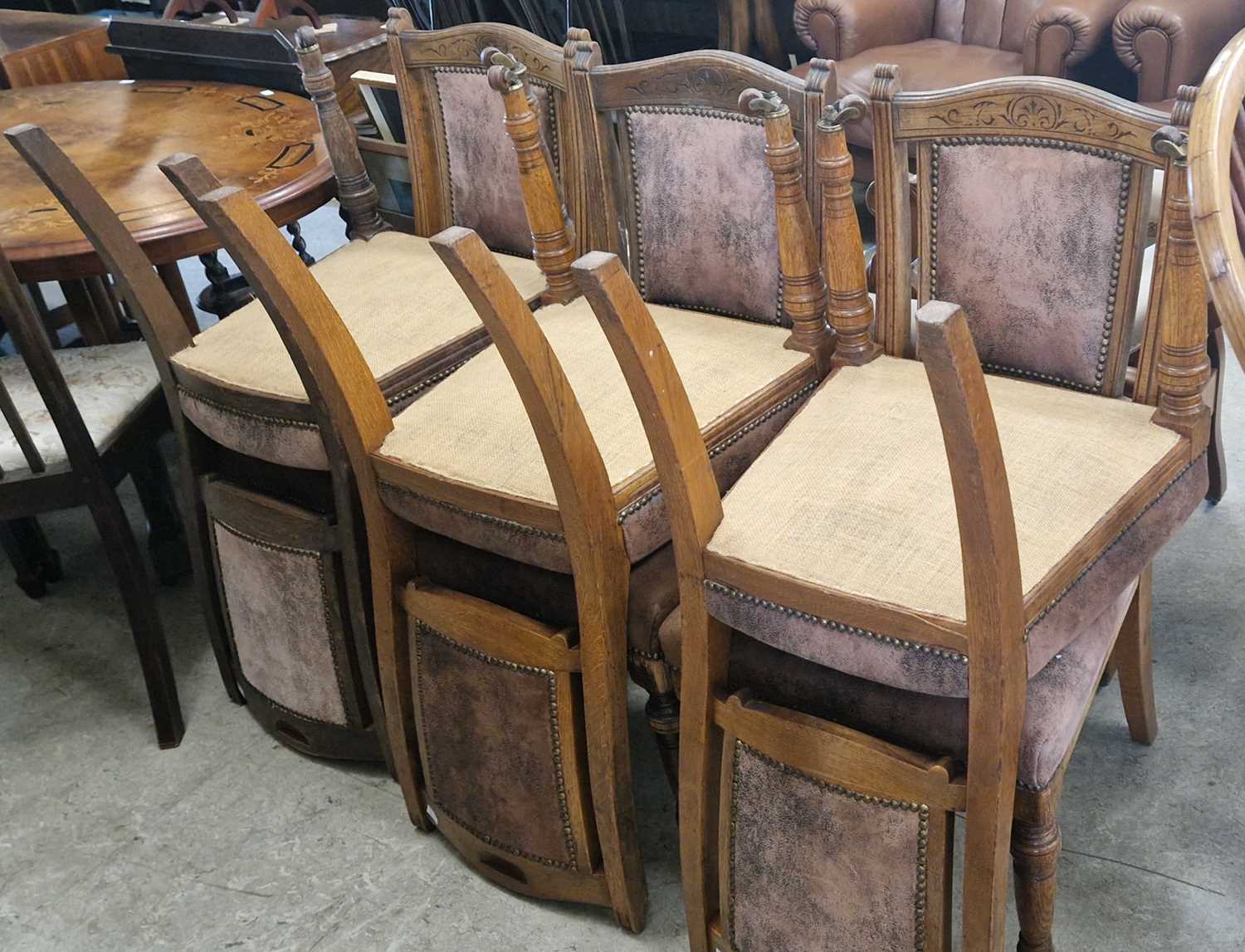 A set of six Victorian oak dining chairs with upholstered backs and seats with brass studded
