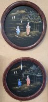 Two Japanese mother of pearl inlaid lacquered circular wall plaques, depicting figures walking in