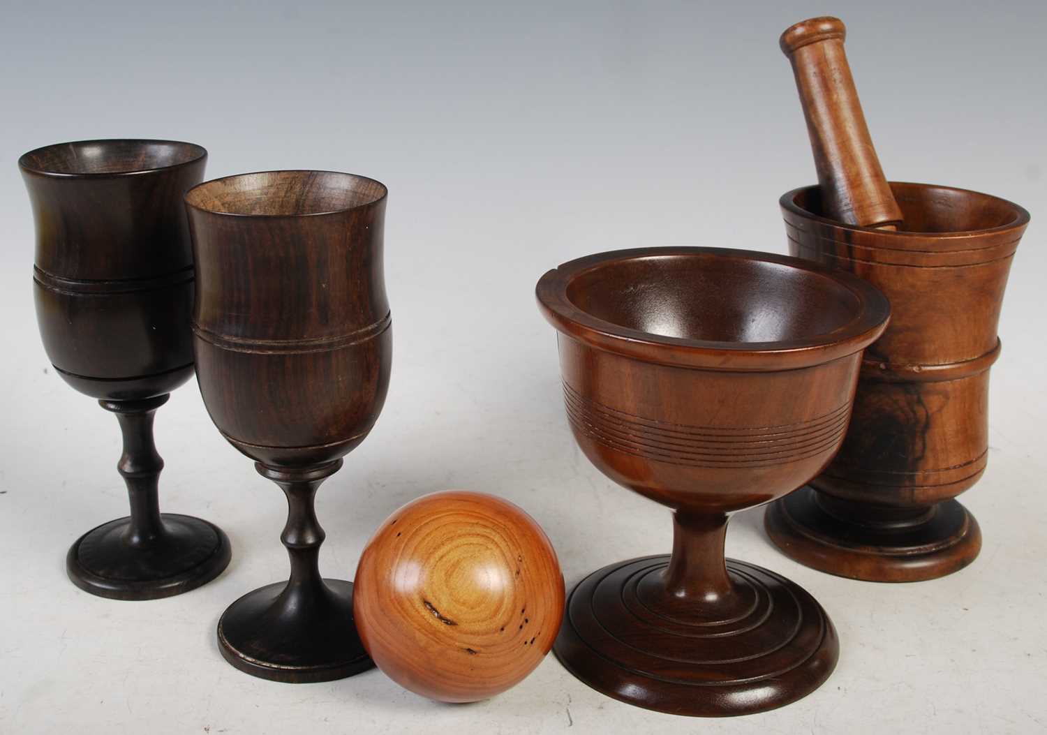 A collection of treen ware to include a Victorian lignum vitae pestle and mortar, the mortar 13cm