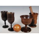 A collection of treen ware to include a Victorian lignum vitae pestle and mortar, the mortar 13cm